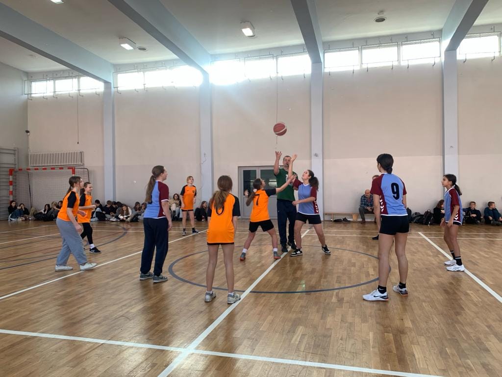 Młodzież w hali sportowej podczas gry w koszykówkę